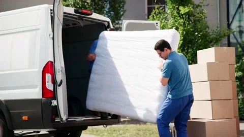 Efficient Movers Transporting Mattress During Moving Day Stock Footage 314136022