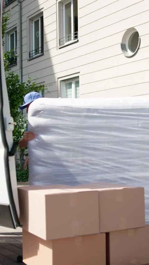 Efficient Movers Transporting Mattress During Moving Day Stock Footage 314137379