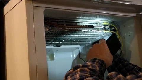Efficient refrigerator repair process seen during nighttime troubleshooting.. Stock Footage 337360621