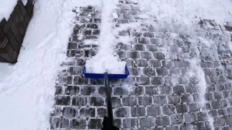 Efficient Snow Removal from Cobblestone Path in Chilly Winter Stock Footage 327831969
