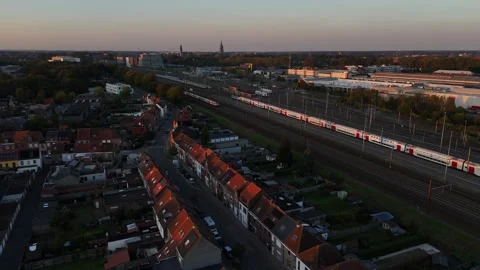 Efficient trains glide through twilight cityscape at dusk near suburban homes Stock Footage 295307147