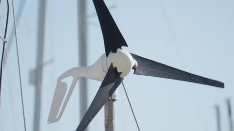 Efficient wind turbine spinning at harbor location during clear weather Stock Footage 313731084