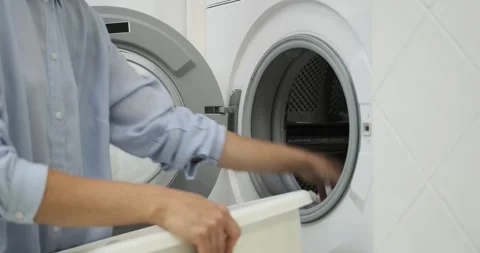 Efficient Woman Loading Soiled Clothes into Washer Stock Footage 250028498