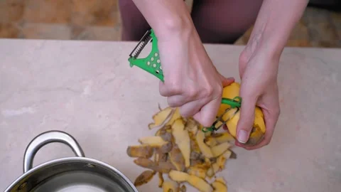 Efficiently peeling potatoes to prepare for shared family dinner 库存影片 328494177