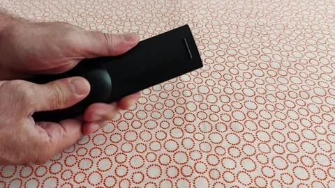 Effortless Control: Hands Remote on Patterned Cloth 스톡 동영상 311500585