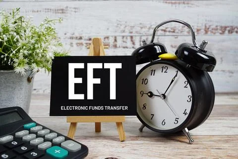 EFT Electronic Funds Transfer text with alarm clock and calculator on woode.. Stock Photos