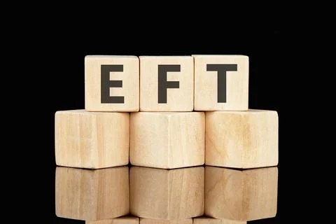EFT text assembled from wooden cubes on a black background Stock Photos