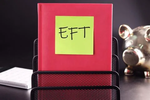EFT text on a yellow sticker pasted on an upright diary on a black background Stock Photos