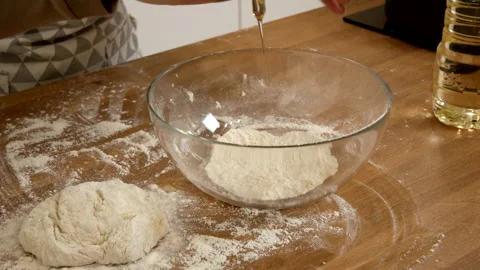 An egg is added to a bowl of flour Stock Footage 208676421