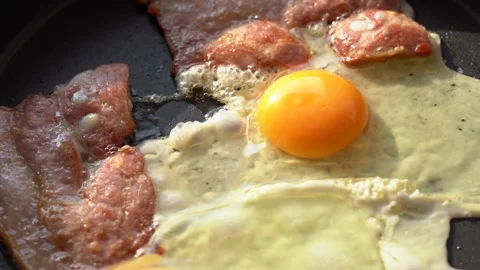 Egg and bacon are cooked in a pan Stock Footage 134606079