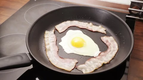 Egg and bacon are fried in a pan,Delicious breakfast combo close up Stock Footage 254236001