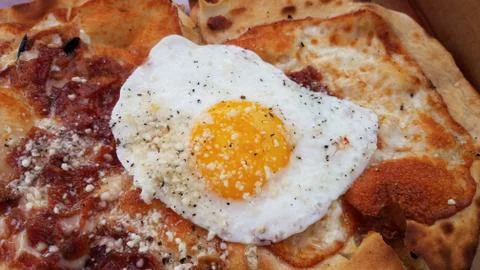 Egg and bacon breakfast pizza in cardboard box Stock Photos