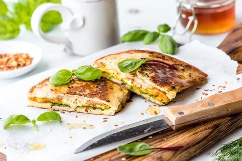 Egg and cheese naan bread breakfast sandwiches topped with honey and basil. Stock Photos