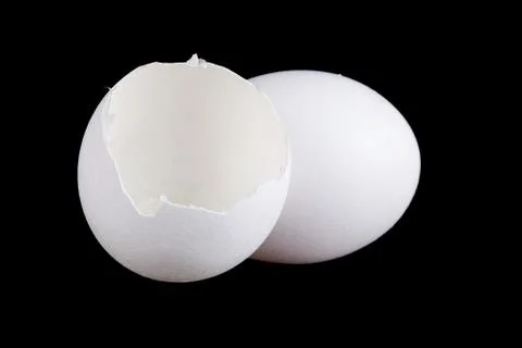 Egg and empty eggshell isolated on black background Stock Photos