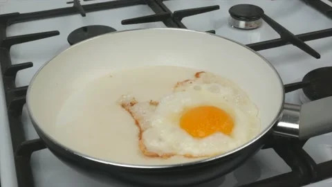 Egg and tomato fried in a pan with a white non-stick coating - quick breakfas Stock Footage 134309564