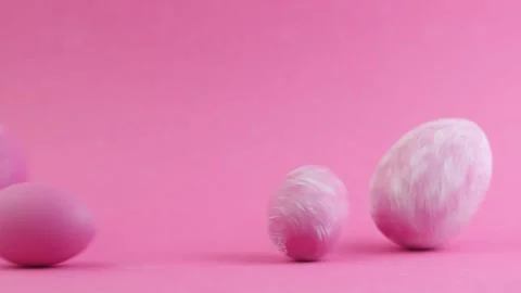 Egg are rolling on the pink background, knock each other. Easter colorful eggs Stock Footage 234713791