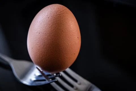 Egg balanced on two forks Stock Photos