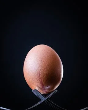 Egg balancing on two forks Stock Photos