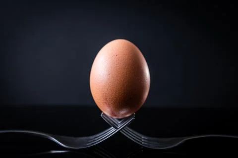 Egg balancing on two forks Stock Photos