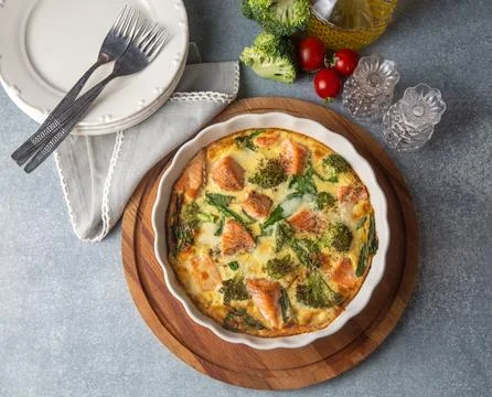Egg-based frittata, omelette with salmon, broccoli and spinach. Italian dis.. Stock Photos