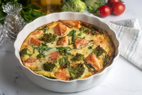 Egg-based frittata, omelette with salmon, broccoli and spinach. Italian dis.. Stock Photos