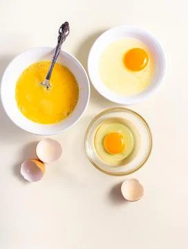 Egg beat, Egg Shell. Raw eggs in a glass and white bowl on the table. Flat .. Stock Photos