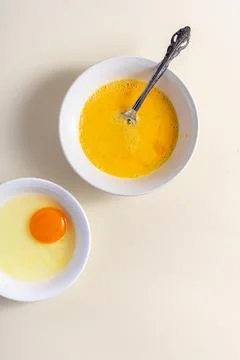 Egg beat, Egg Shell. Raw eggs in a glass and white bowl on the table. Flat .. Stock Photos