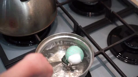 Egg in a beautiful shrink wrap, dipped on a spoon in boiling water Stock Footage 151979571