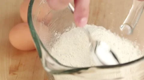 An egg being added to a flour well Stock Footage 24671743