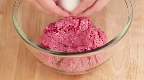An egg being added to minced meat Stock-Footage 24671838