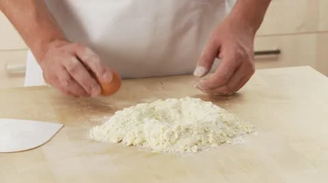An egg being added to a well in flour 스톡 동영상 24641875