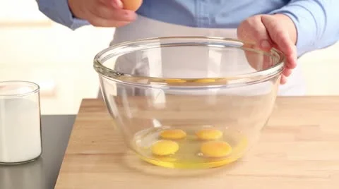 An egg being cracked into a bowl and sugar being added 스톡 동영상 24657112