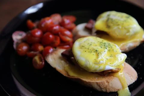 Egg benedict in close up on wood background Stock Photos