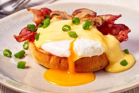 Egg Benedict with fried bacon and hollandaise sauce Stock Photos