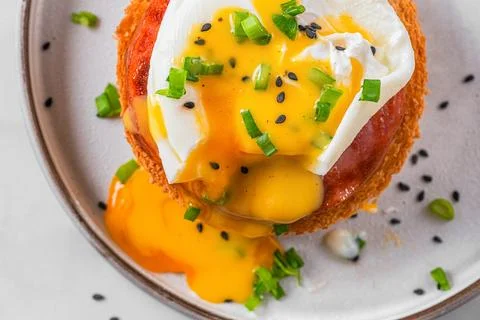 Egg benedict. Poached egg, ham, hollandaise sauce, onion on slice toast for.. Stock Photos