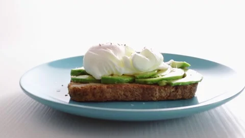 Egg Benedict,classic poached egg on toasted bread with avocado and juicy yolk Stock Footage 252381152