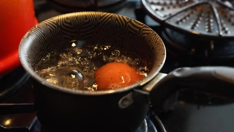 Egg Boiling in a Pot on a Lit Stove with Bubbling Water Видео 283926215