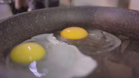 Egg breaks and flows into the pan. Healthy breakfast concept. Fried eggs Stock Footage 193986132