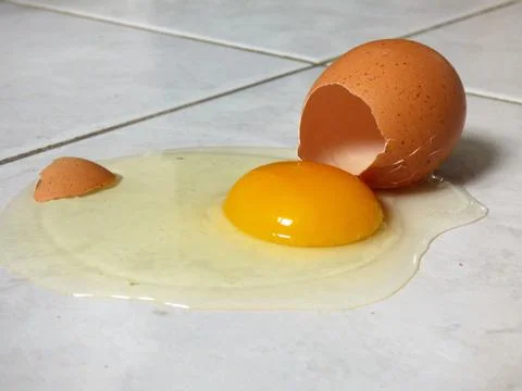 Egg broken on a floor tiles Stock Photos