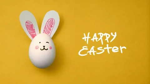 Egg with bunny face and ears, text Happy Easter on yellow Video stock 306552351