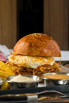 Egg burger with crispy potatoes served with fries and sauces Stock Photos