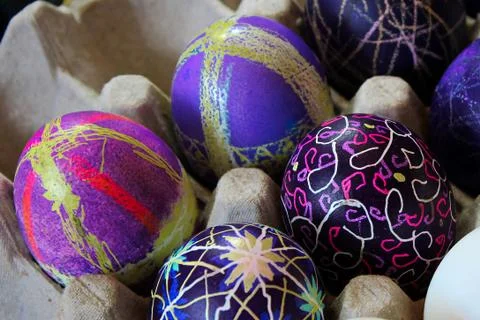 An egg carton holding decorated easter eggs Stock Photos