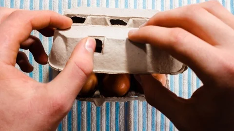 Egg carton stop motion hands opening box. Eggs cracked &amp; empty then Video stock 114433173
