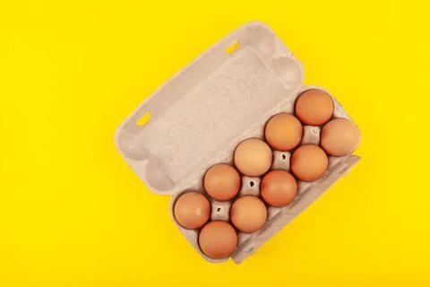 Egg Chicken eggs. Top view of an open gray box with brown eggs Isolated on a Stock Photos