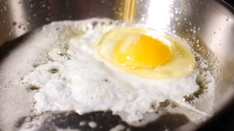 Egg cooking in pan close up in slow motion ready breakfast Stock Footage 153193209