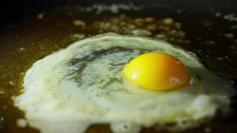 Egg Cracking Onto Hot Pan with Rapid Sizzling and Bubbling Macro Stock Footage 308209018