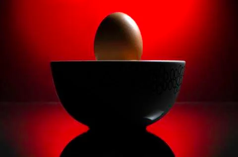An egg with a dramatic red background. Stock Photos