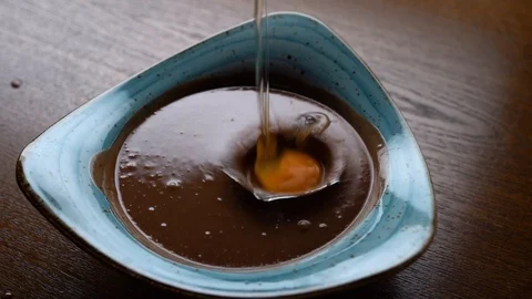 Egg Dropped in a Chocolate Pudding Stock Footage 128190266