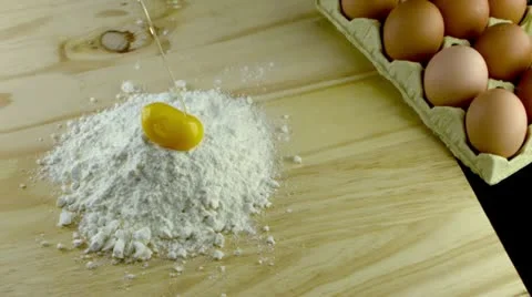Egg dropping into flour Vídeos de archivo 11942361