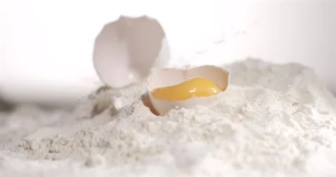 Egg drops into flour in slow motion detail Stock Footage 344985283